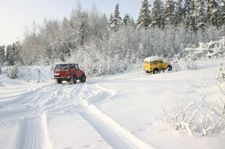 Kaksi maastoautoa lumisella aukiolla